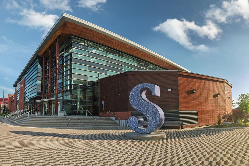 Modern building facade with large glass windows and a prominent sculptural letter S in Oakville, ON. Takeoff-Moving Toronto