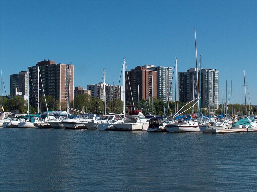 Oakville marina with sailboats and apartment buildings along the waterfront. Takeoff-Moving Toronto